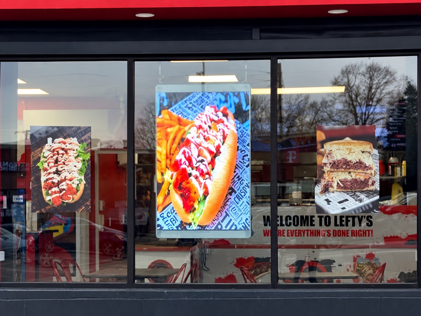 Transparent LED window display showing vibrant food content at Lefty's Famous Cheesesteaks in Livonia, Michigan