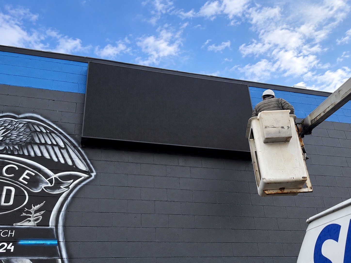 Bucket-lift installation of a wall-mounted LED display in Melvindale