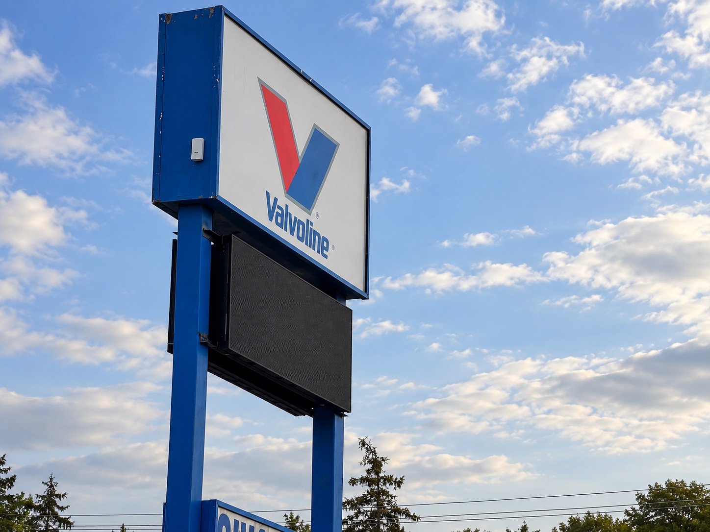 Full roadside view of the Port Huron Valvoline pylon sign and LED display