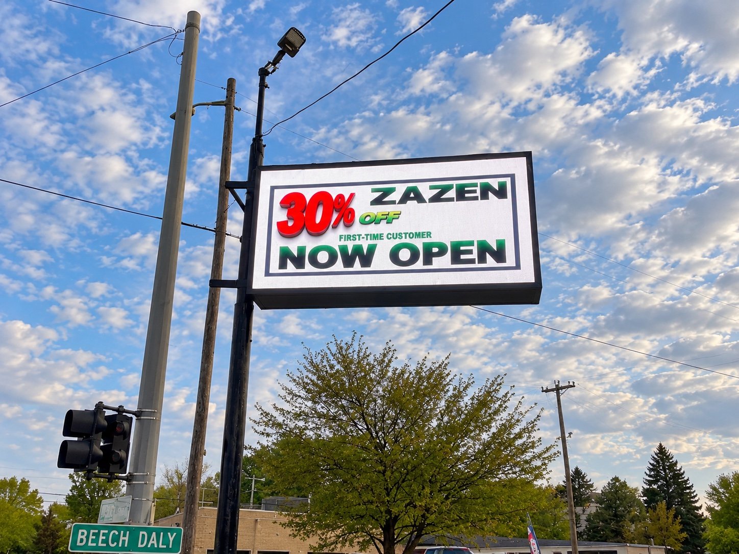 Close view of the completed Zazen LED pole sign beside Beech Daly Road