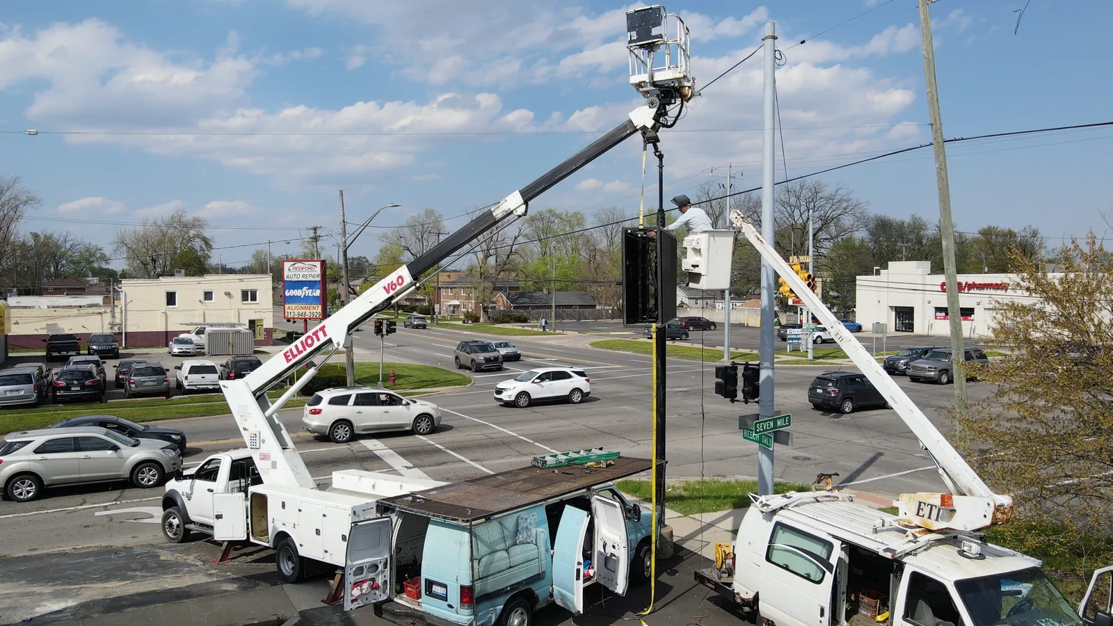 Lift trucks placing the Zazen outdoor LED pole sign in Redford Township