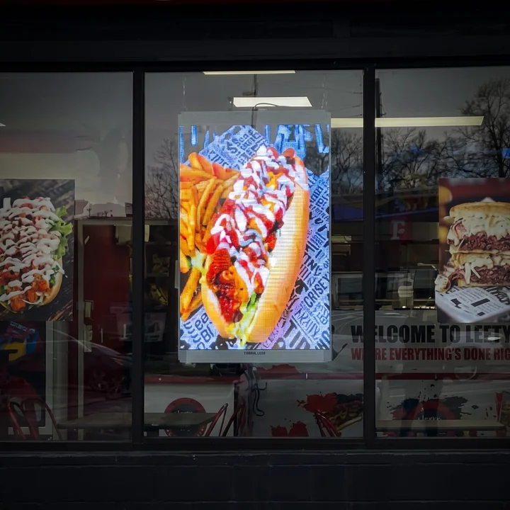 Transparent LED window advertising display across restaurant storefront glass